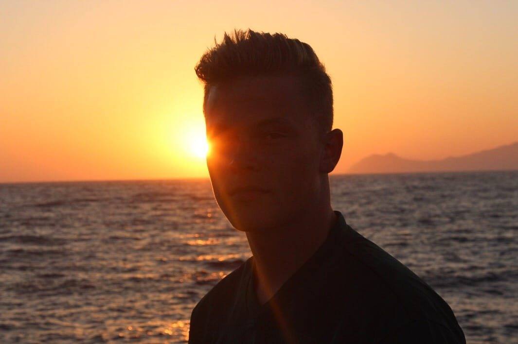 Niklas als Silhouette vor der tief stehenden Sonne über dem Meer.